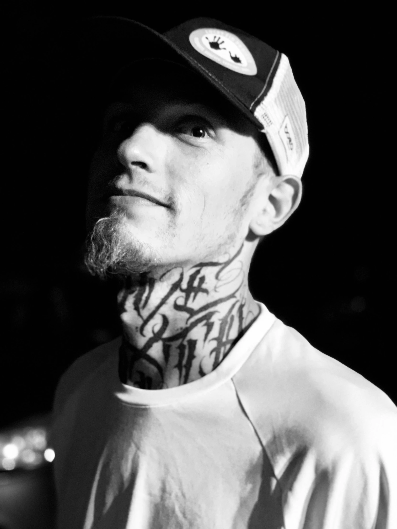 a man with tattoos on his neck is wearing a hat