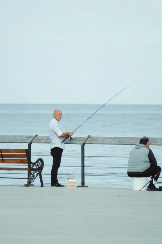 a man fishing with his grandson on the pier