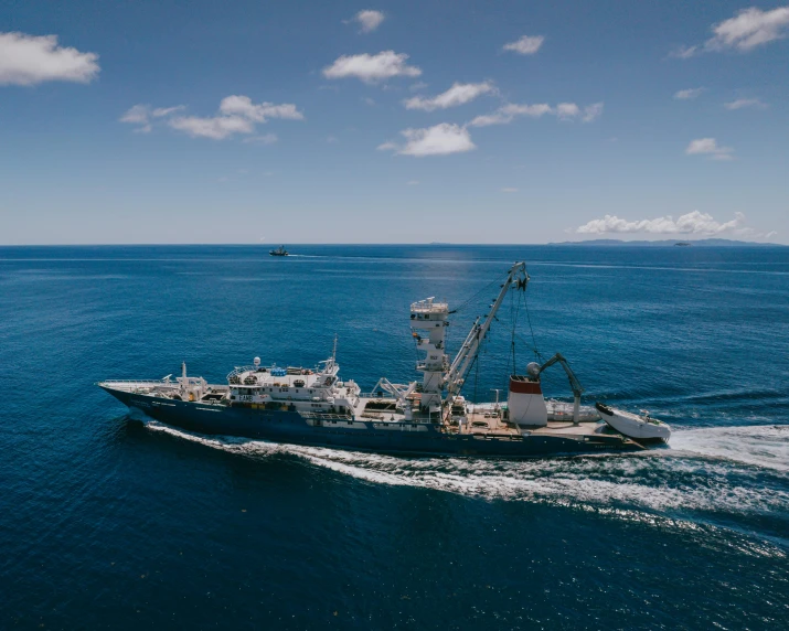 large boat on open water, with a lot of clouds in the sky