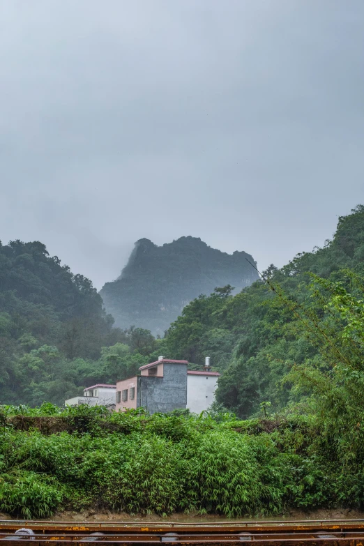 a building sitting among some lush greenery under a cloudy sky