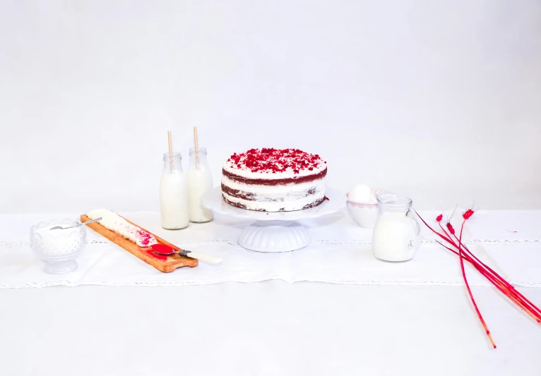 red and white cake with sugar, milk and straws