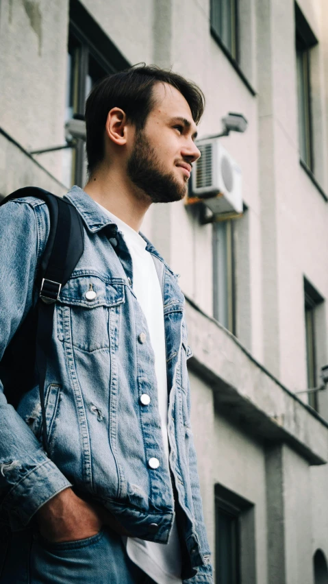 a man is standing near a tall building