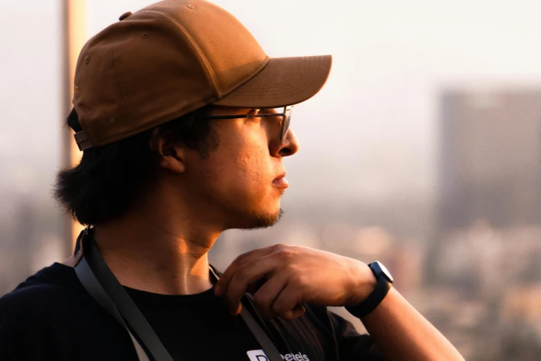 a man in black shirt and hat on top of a hill