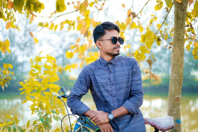 a man in sunglasses stands next to a bike