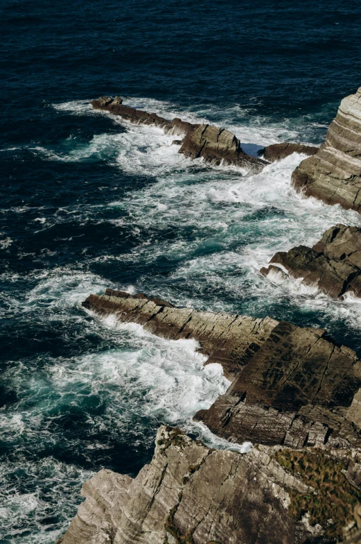 large rocky outcropping with rough waves in the sea