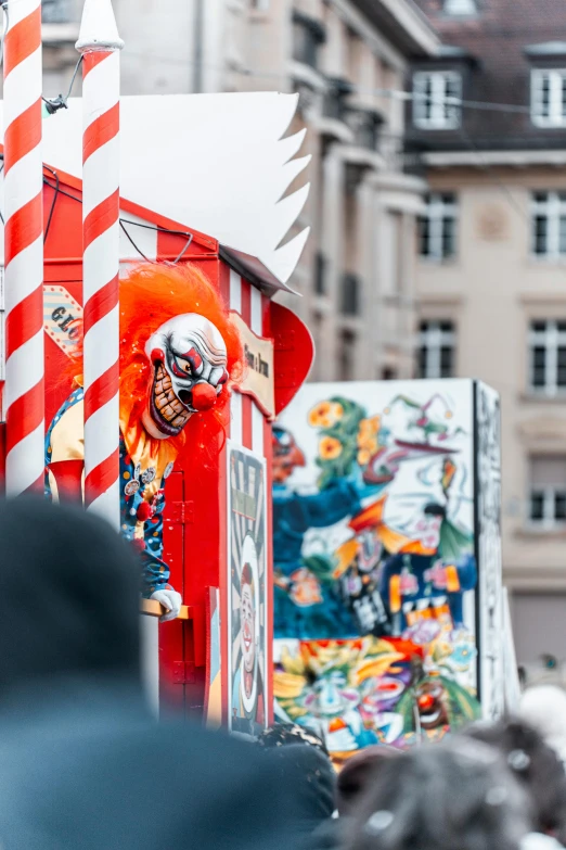 a clown wearing a mask is in an orange box at the end of a street