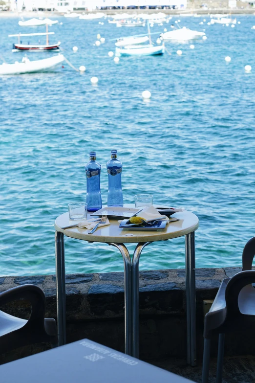 the table and chairs are set with a view of boats