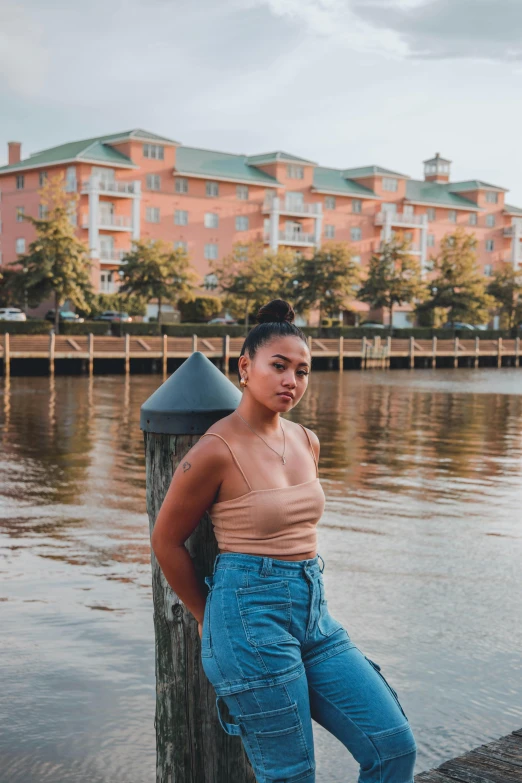 an african american woman posing for a po by a water dock