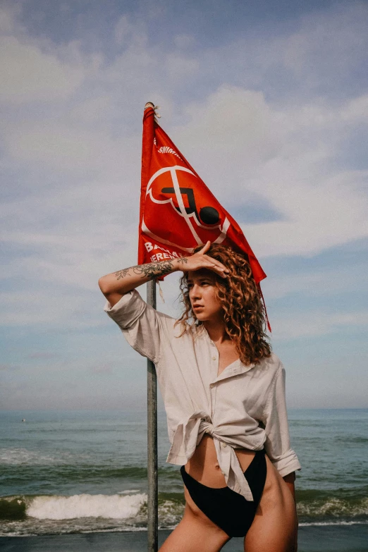 a girl standing by the ocean holding an turkish flag