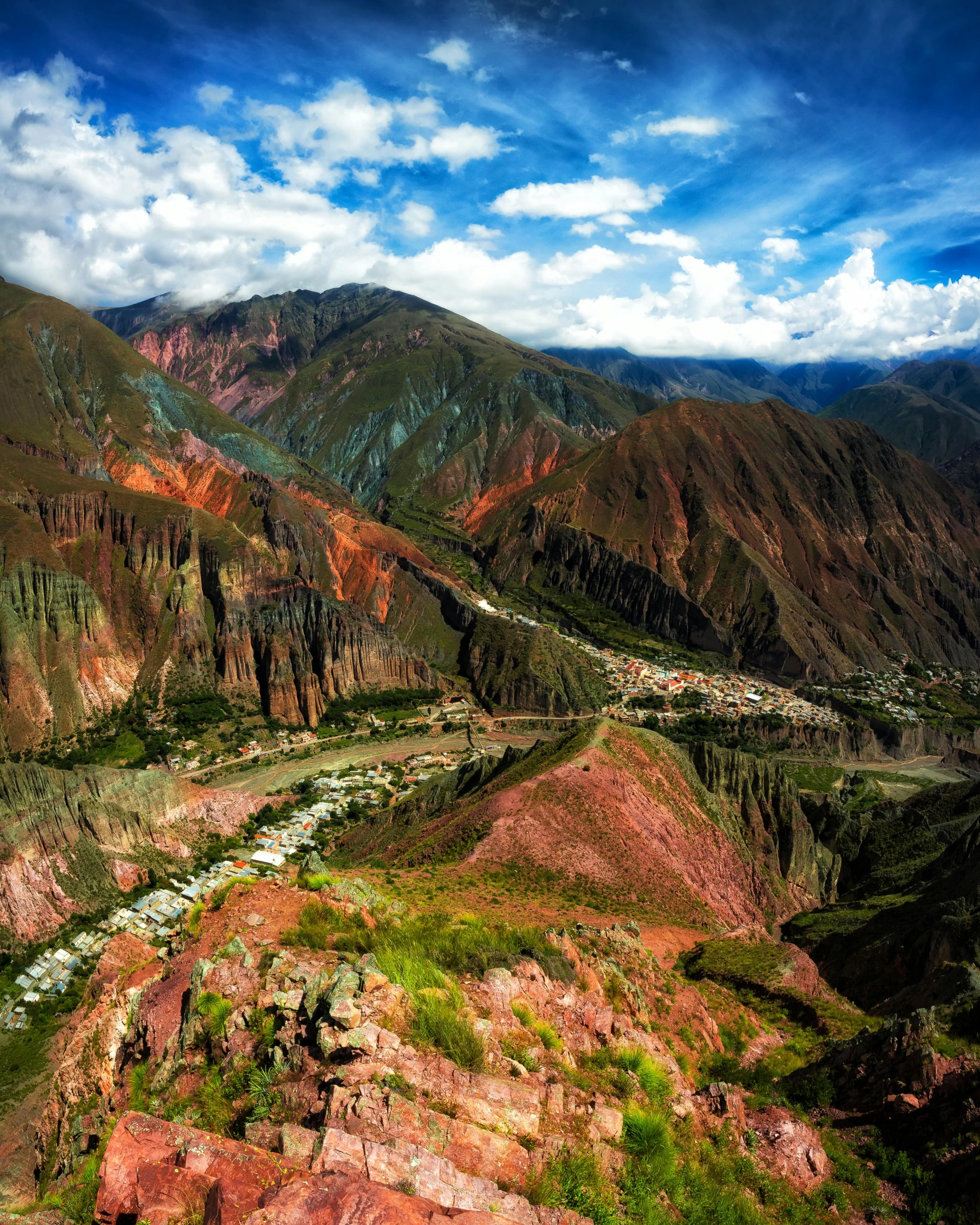 a landscape of green, brown and orange mountains