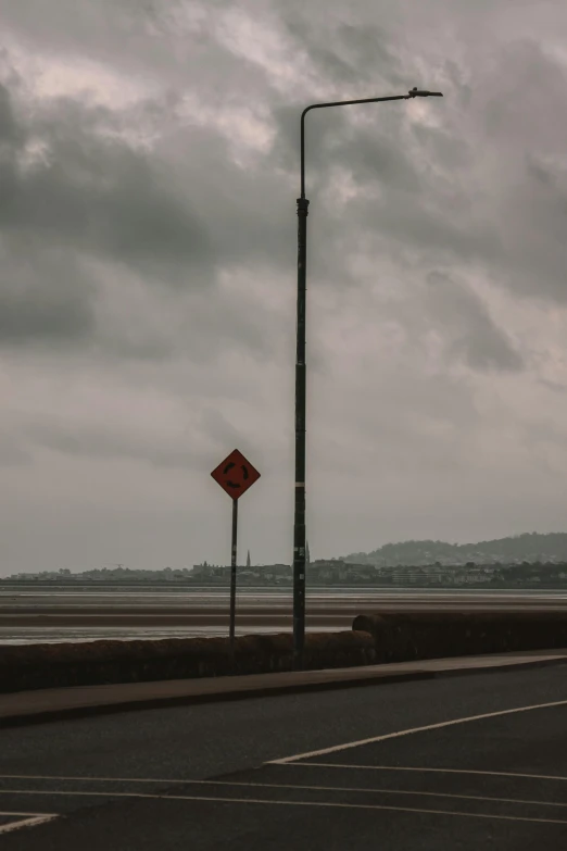 a cloudy view of a red sign by the road