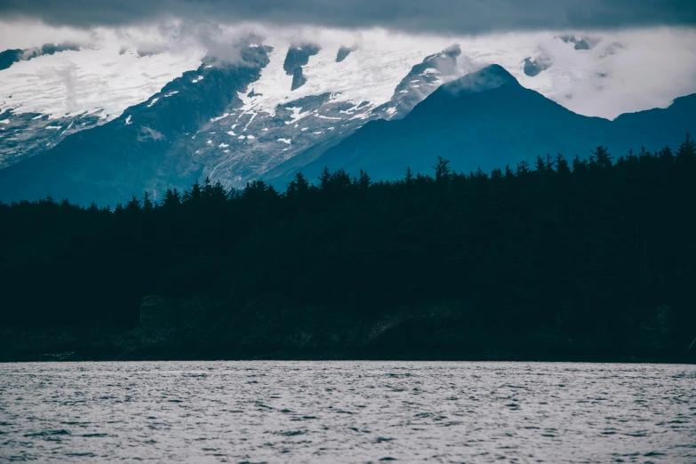 the mountains and trees are on the far bank