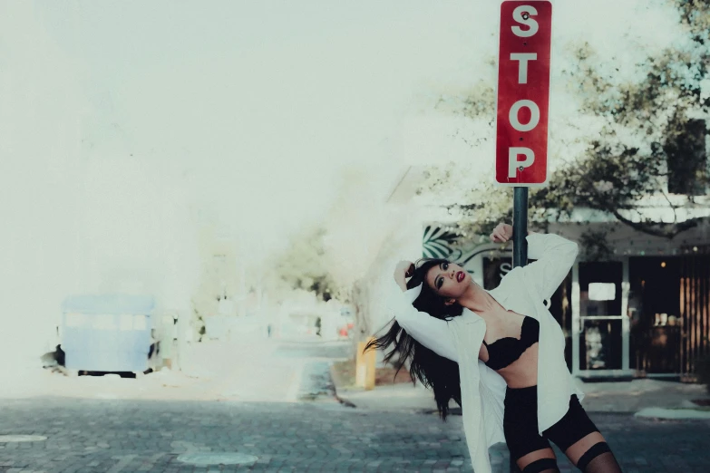 a woman standing on the corner holding a stop sign