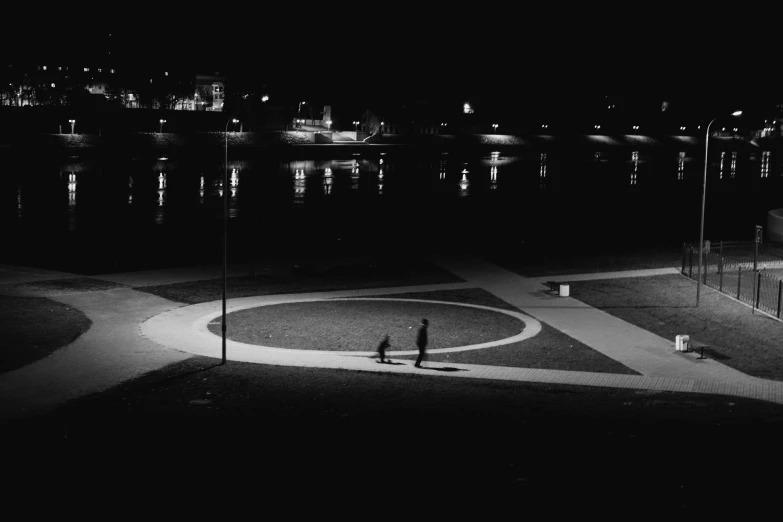 a man standing next to a water at night