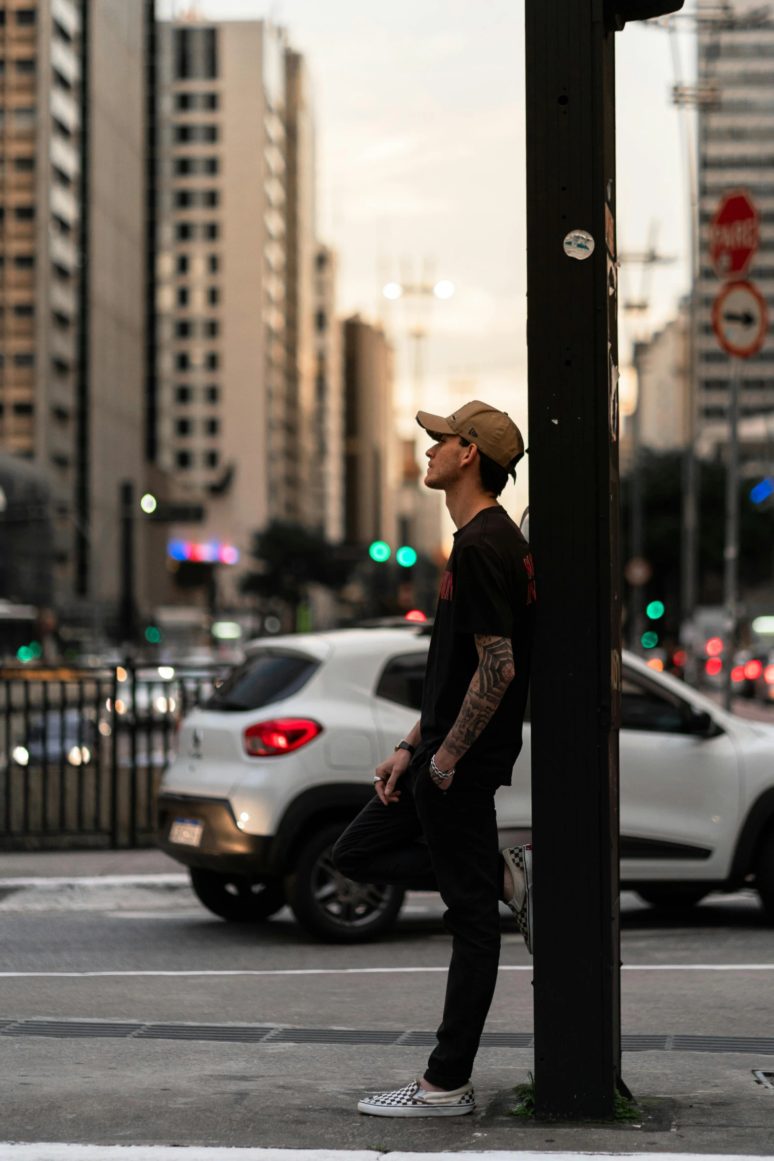 a young man waits for a traffic light