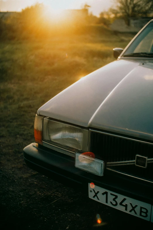 a car parked on top of a field near the sun