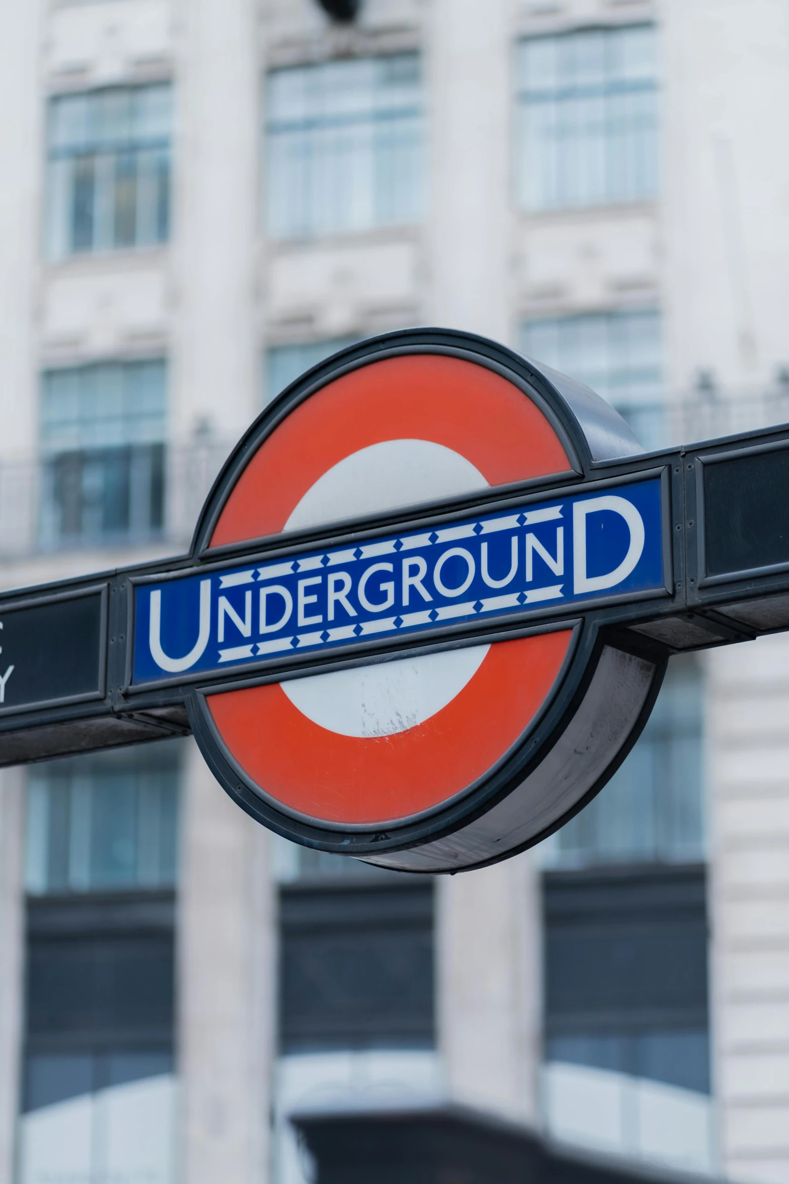 underground sign next to a building in the city