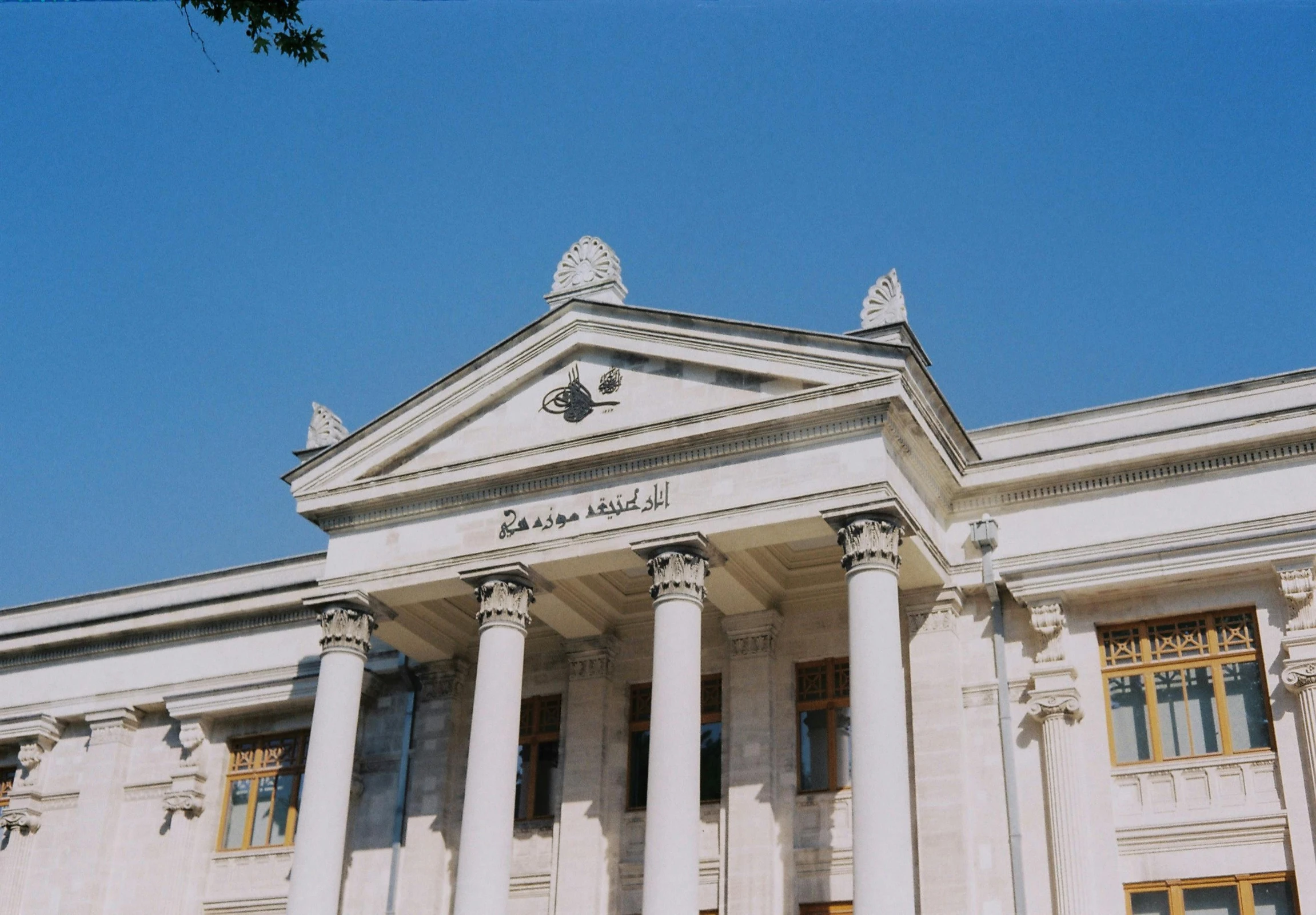 the building has many pillars with windows and lettering on the front