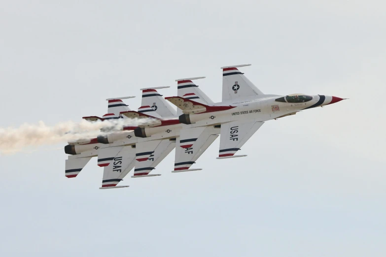 four red white and black jet flying in the sky