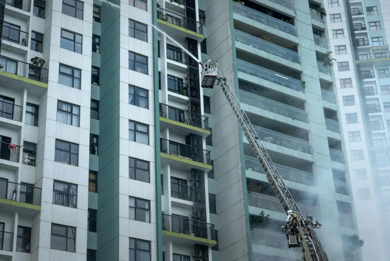 a crane in front of tall buildings on a cloudy day