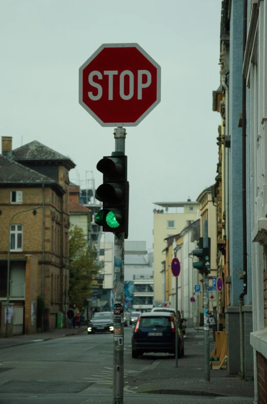 a stop sign with a green light is in the foreground
