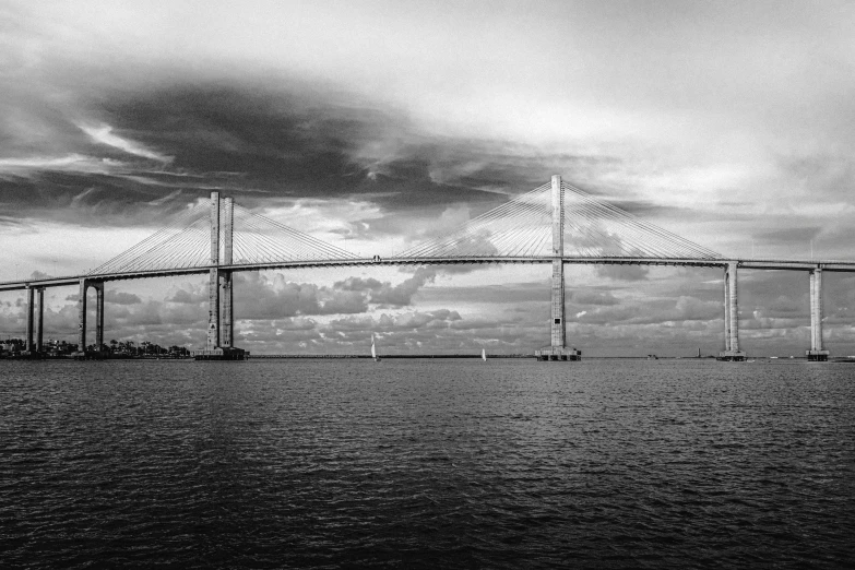 an overhead view of the bridge and the water in a black and white po