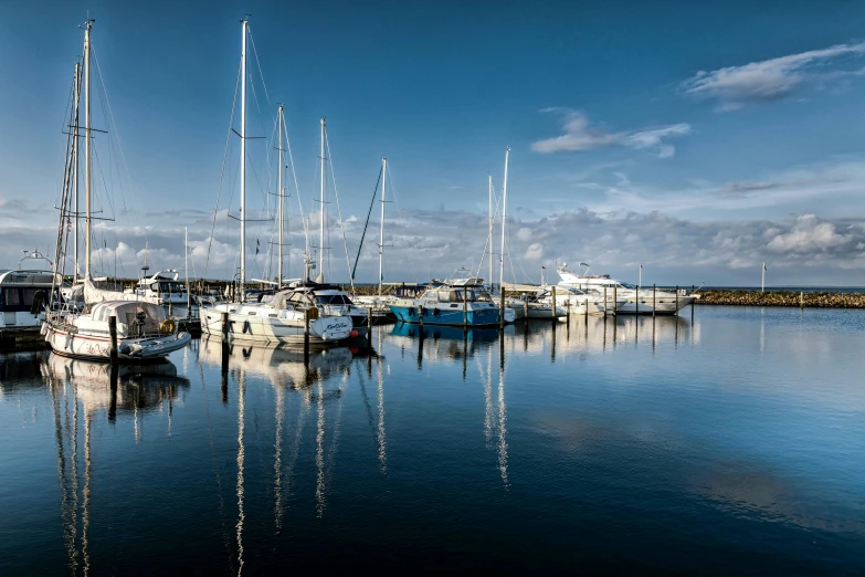 boats in the water are reflected on a blue day