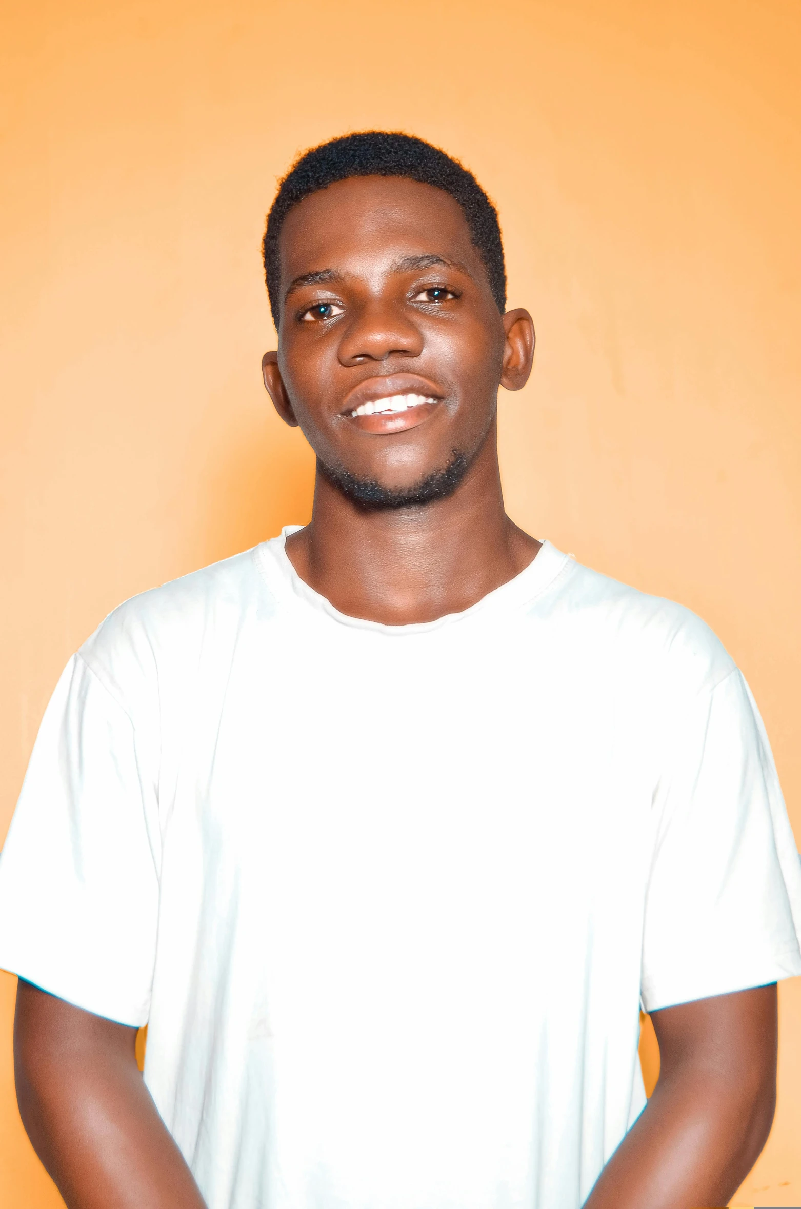 man in white shirt standing next to orange wall