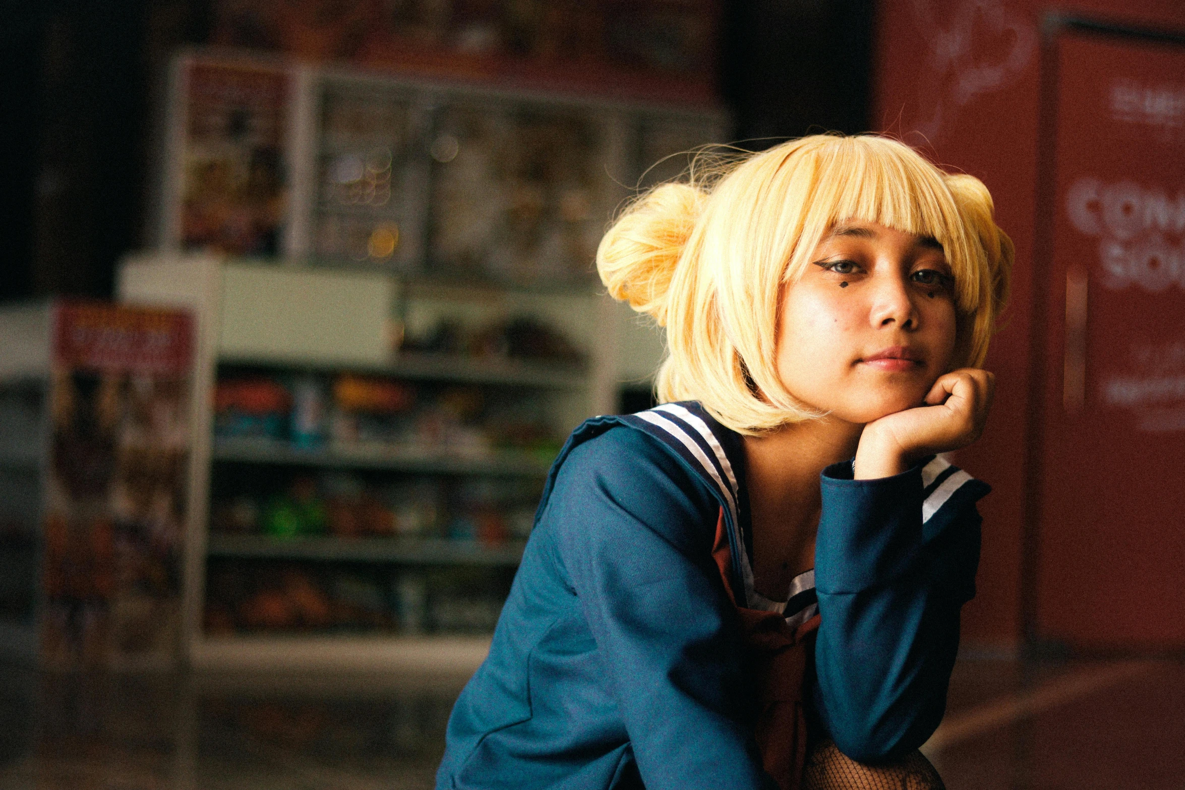 a girl leaning on the wall with her hand near her face