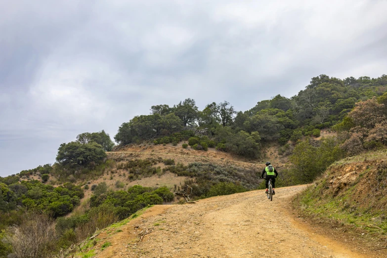 a person riding down a trail near a hill