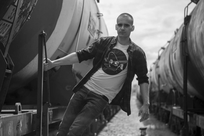 a black and white po of a man with his luggage next to a train