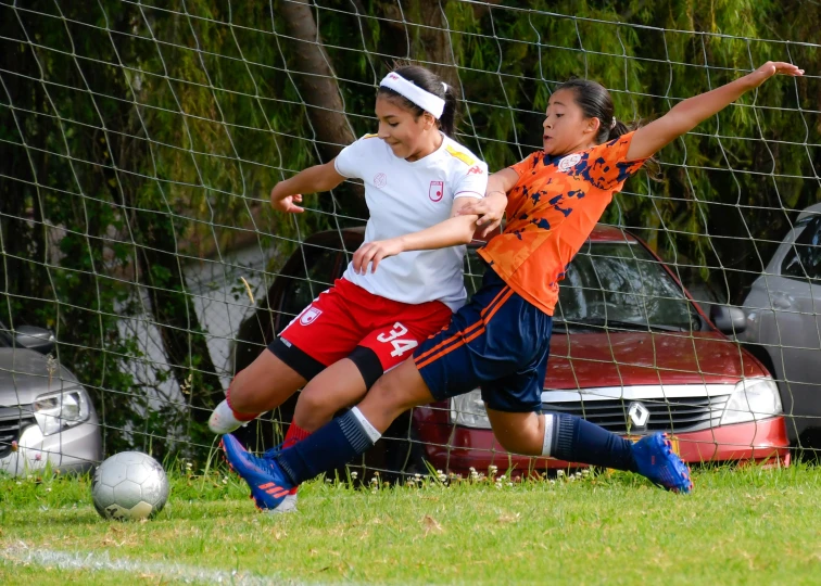 two girls on opposing teams are playing soccer