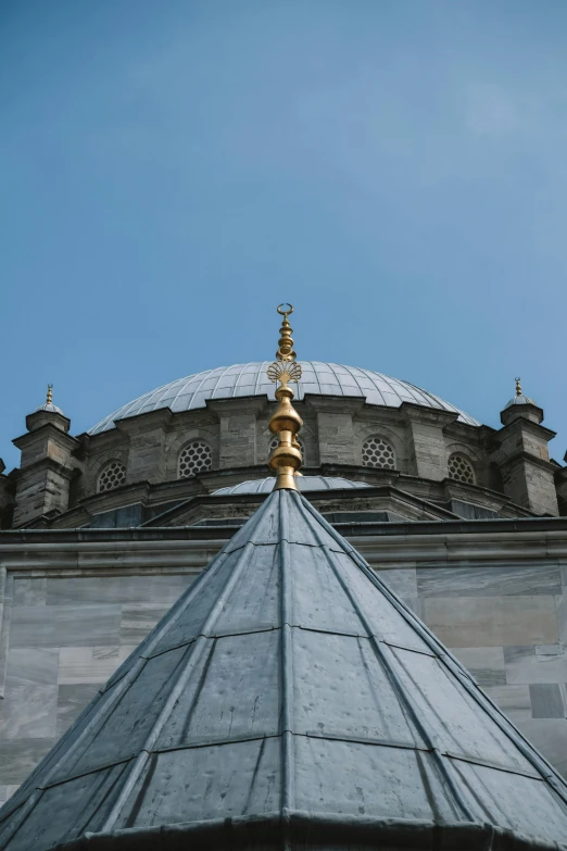 the dome and its gold spire at the top of an old building