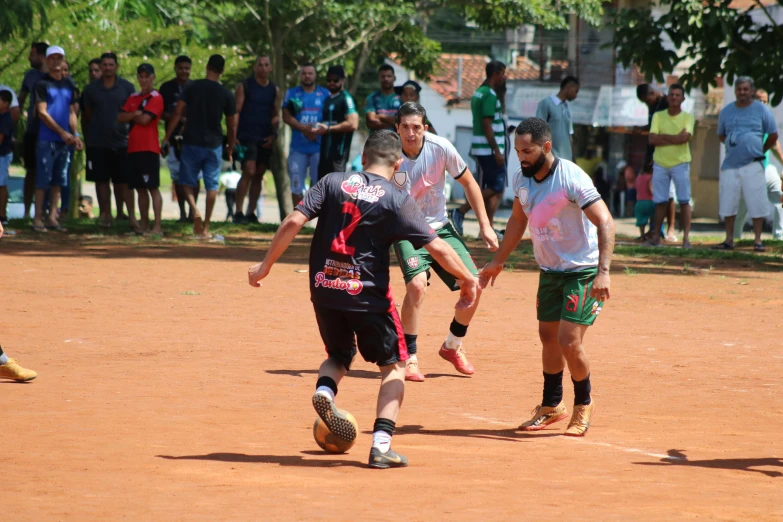 two people playing soccer on an empty dirt field