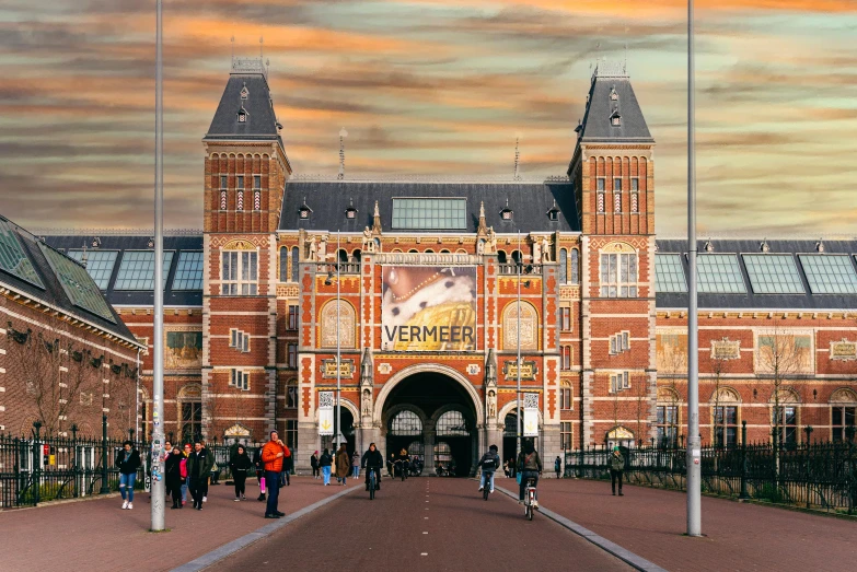 people walking by the entrance to a large brick building