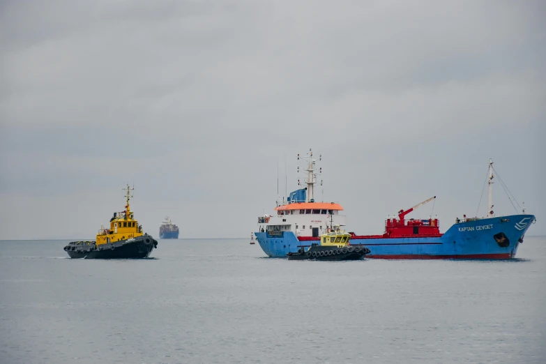 two large ships with smaller boats off to the side