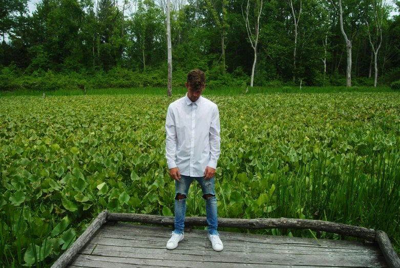 a man standing in a field with lots of green grass