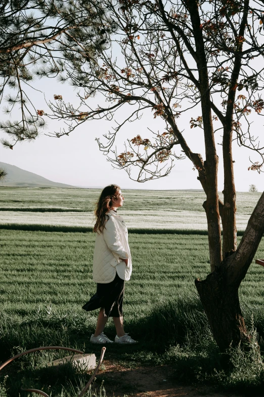 a person standing by a tree in the grass