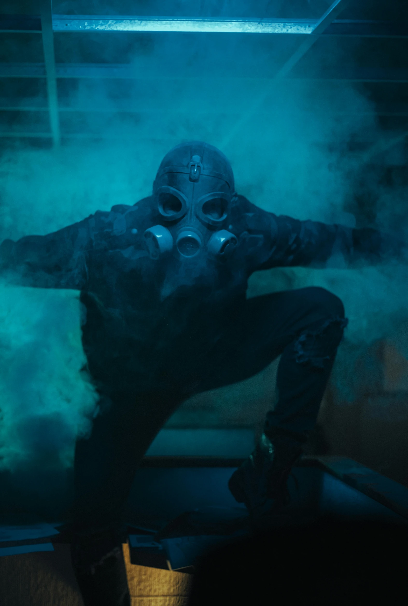 a man dressed in a gas mask sits on a stool