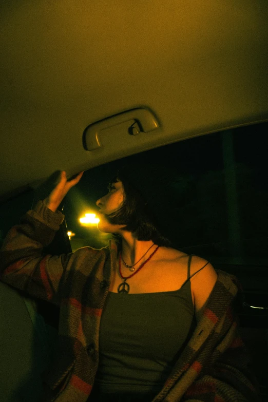 the back of a car is showing a person holding a light up in her hand