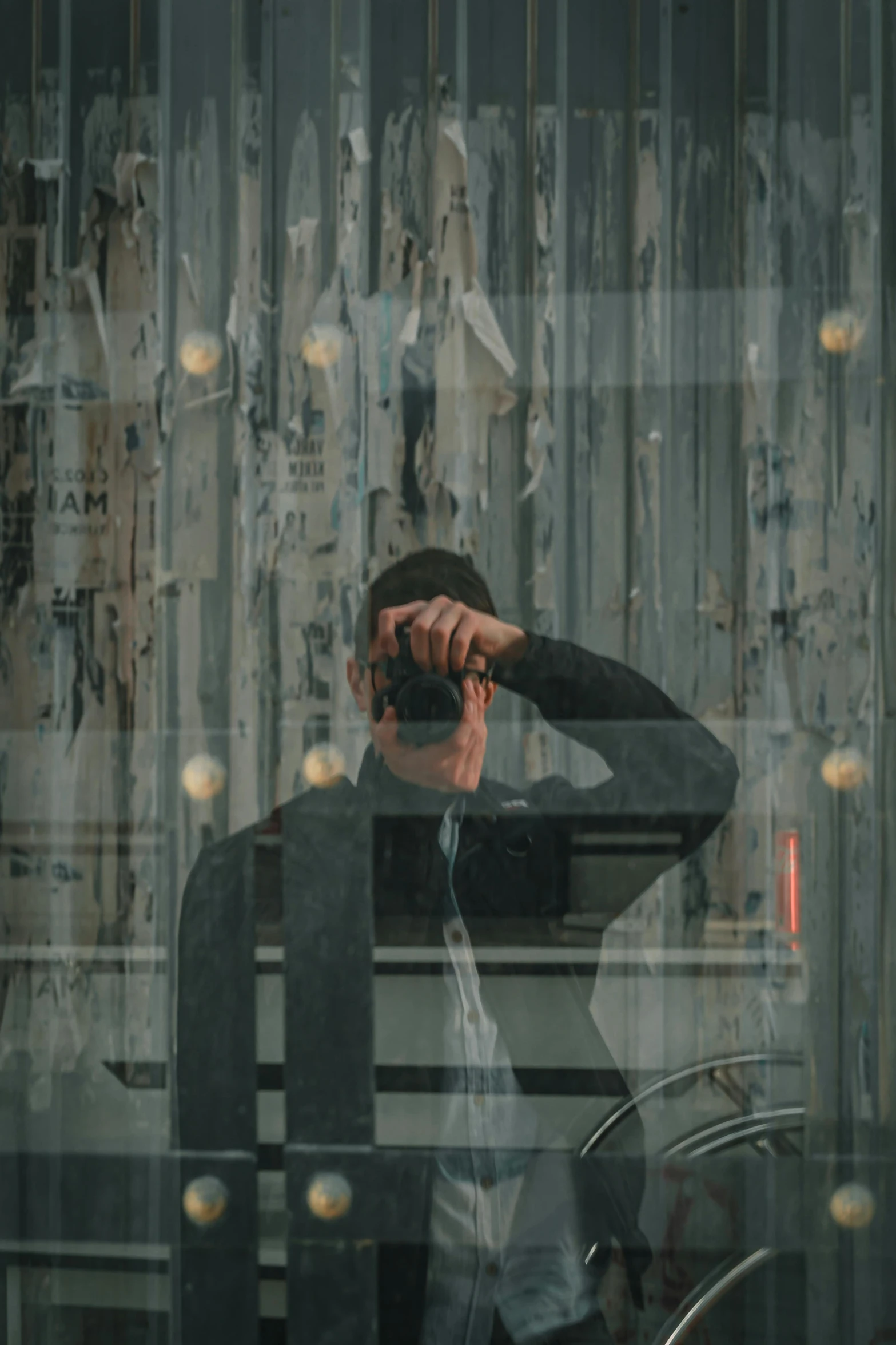 a man standing next to a bike wearing a jacket and holding his head