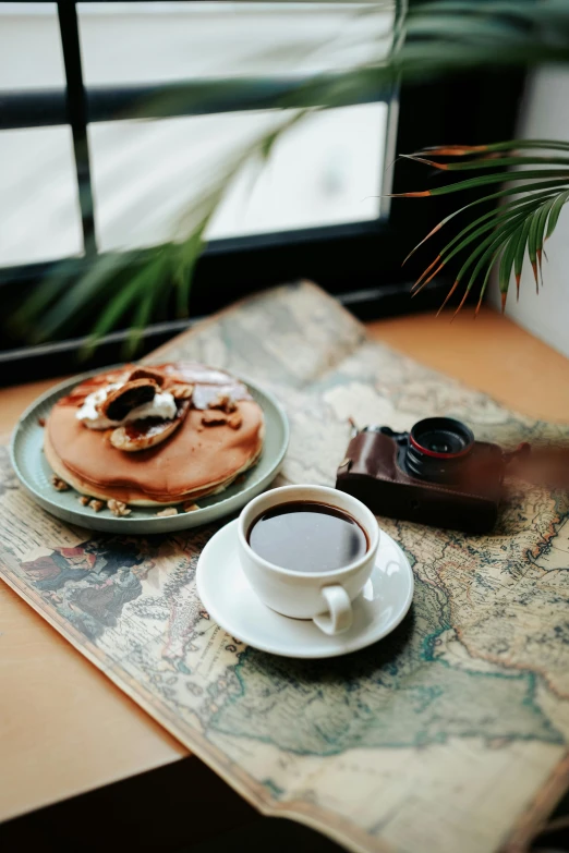 a close up of a cup of coffee and pastry on a table