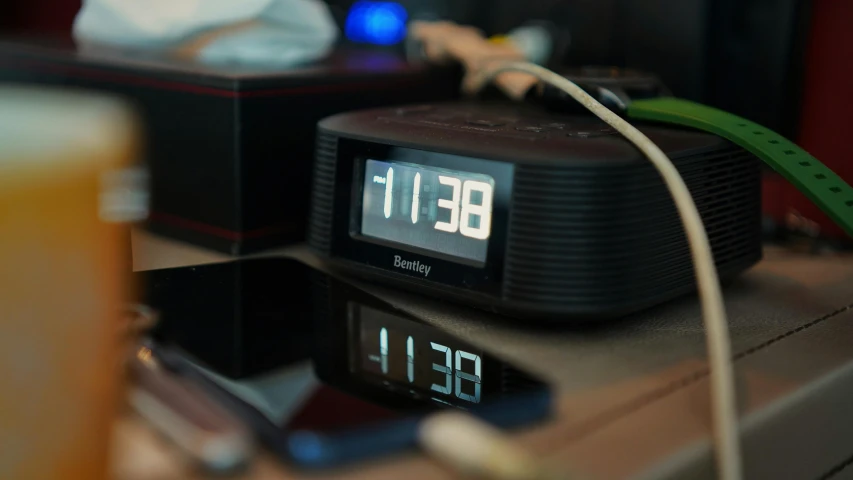 the clock is sitting on a table with a beverage in front