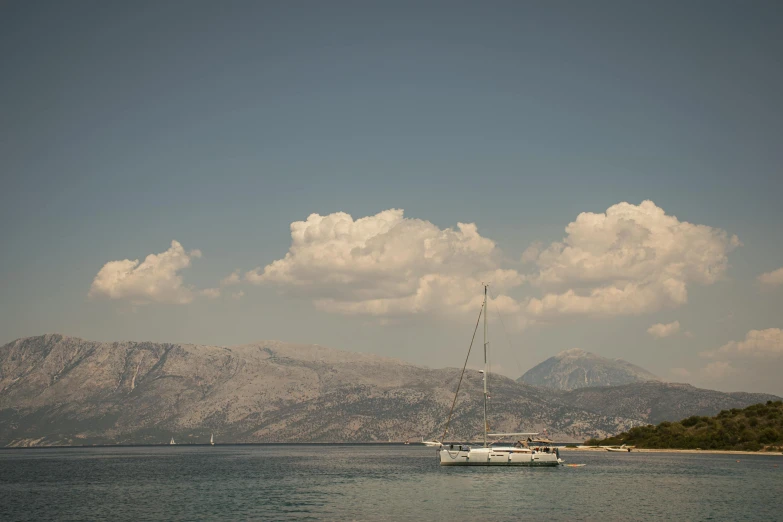 sail boat on calm water with mountains in background