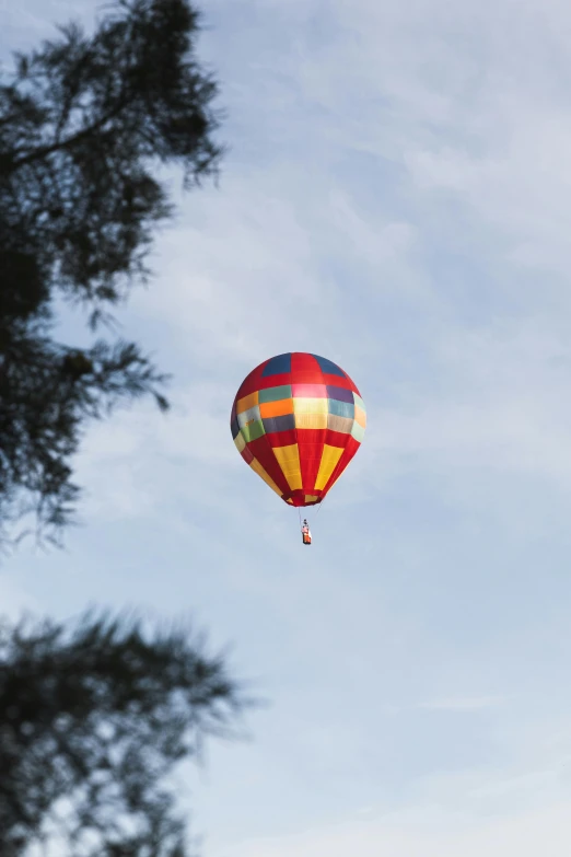 a multi colored  air balloon is in the sky