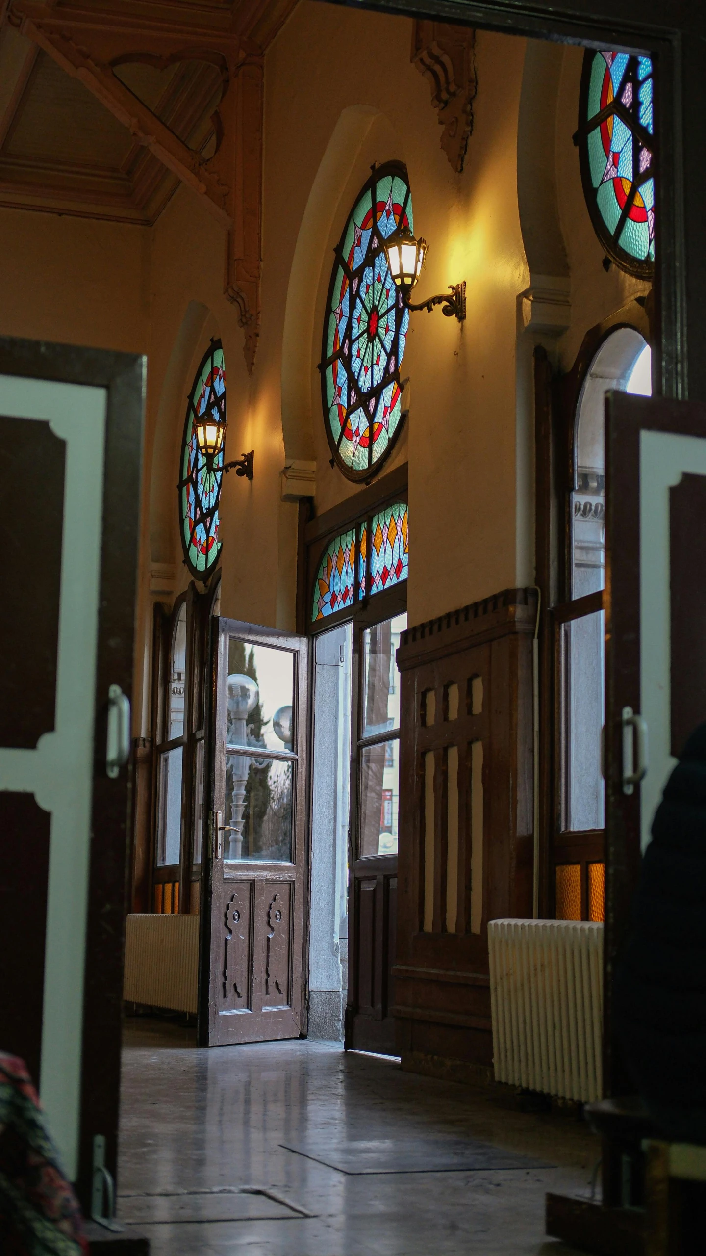 an entry way inside an ornate church with stained glass windows