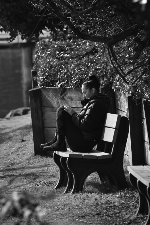 a person is sitting on a bench by the water