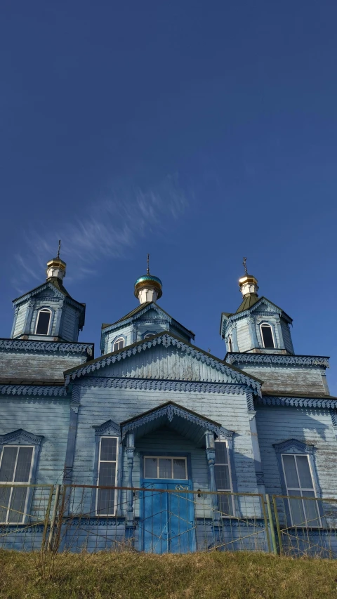 an old blue church with blue windows and a blue sky