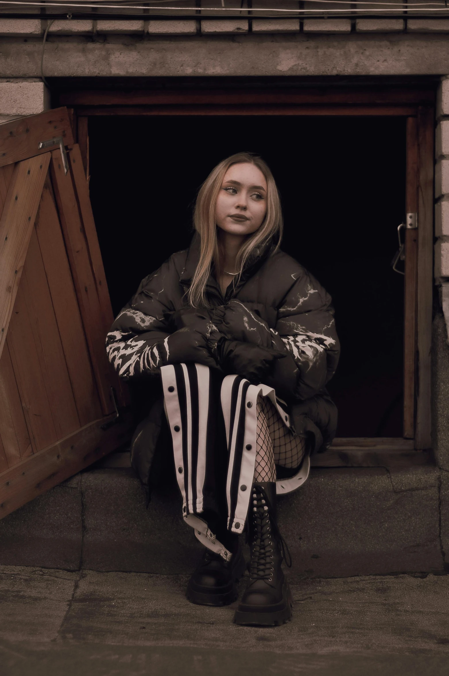 a woman sits in the doorway of her home