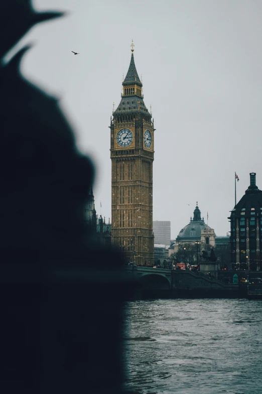 a tall clock tower towering over a river